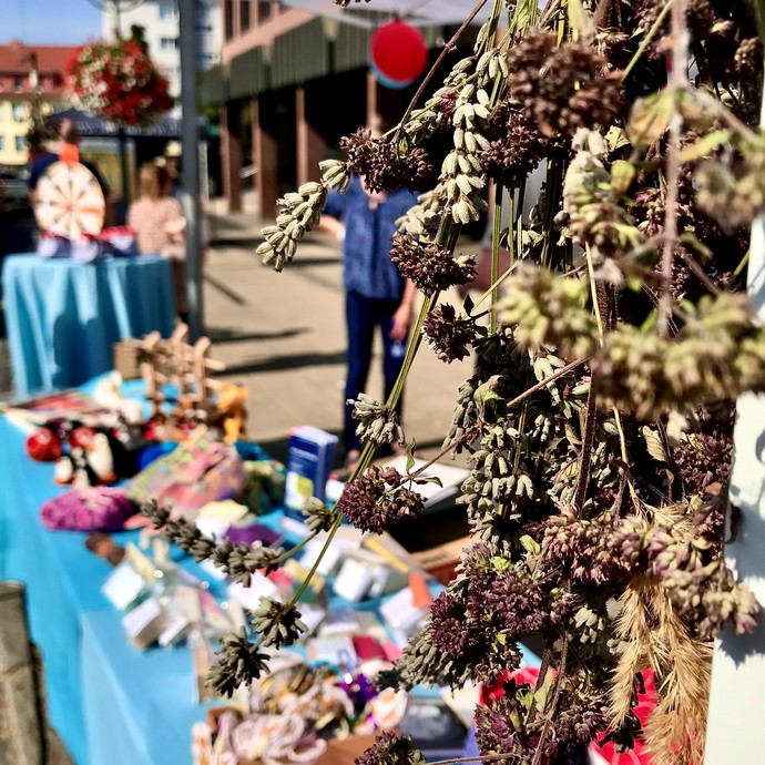 Ein Trockenblumenstrauss. Im Hintergrund Waren, die auf einem Verkaufstisch ausgelegt sind (vergrößerte Bildansicht wird geöffnet)
