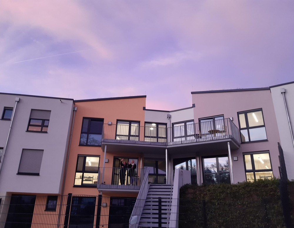 Die frische und bunte Fassade des Wohnhauses am Steinbach vor abendlichem Himmel