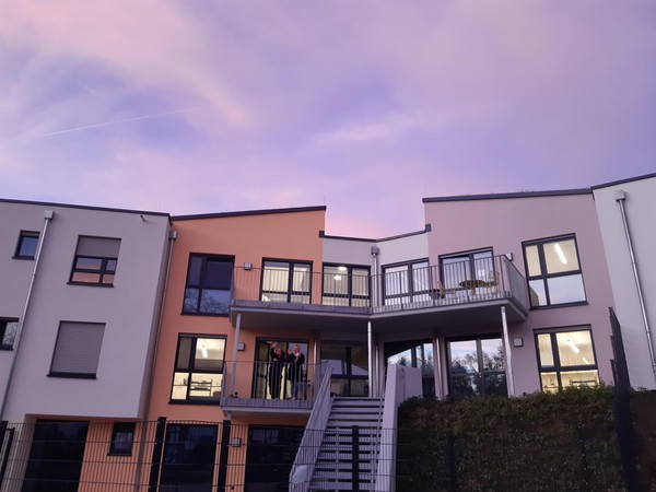 Die bunte und fröhliche Außenfassade des Hauses am Steinbach vor abendlichem Himmel