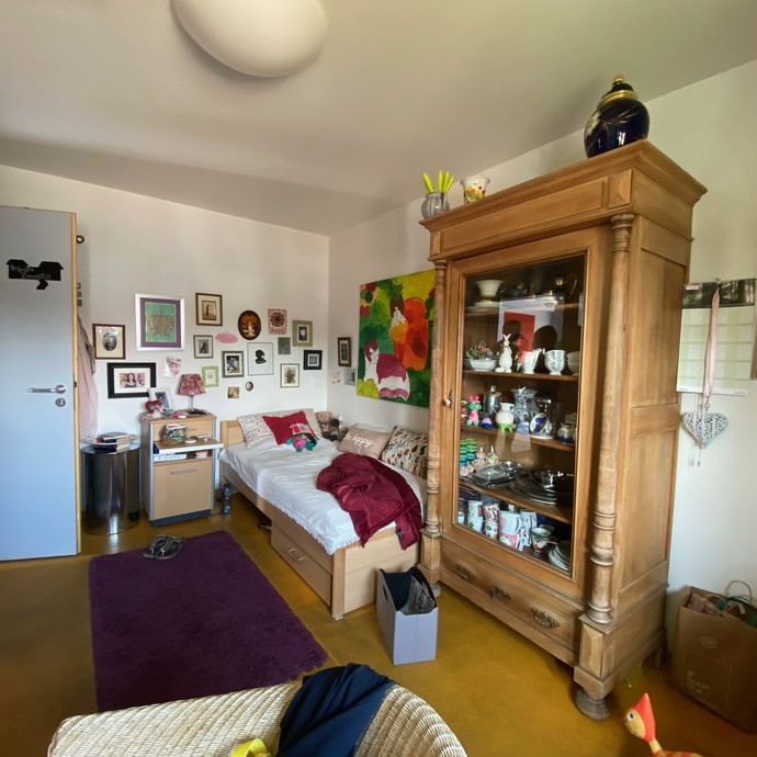 Blick in ein gemütliche eingerichtetes Zimmer. Mit antikem Schrank und Bett (vergrößerte Bildansicht wird geöffnet)
